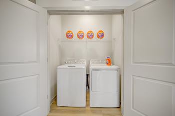 Two white washing machines in a small laundry room.